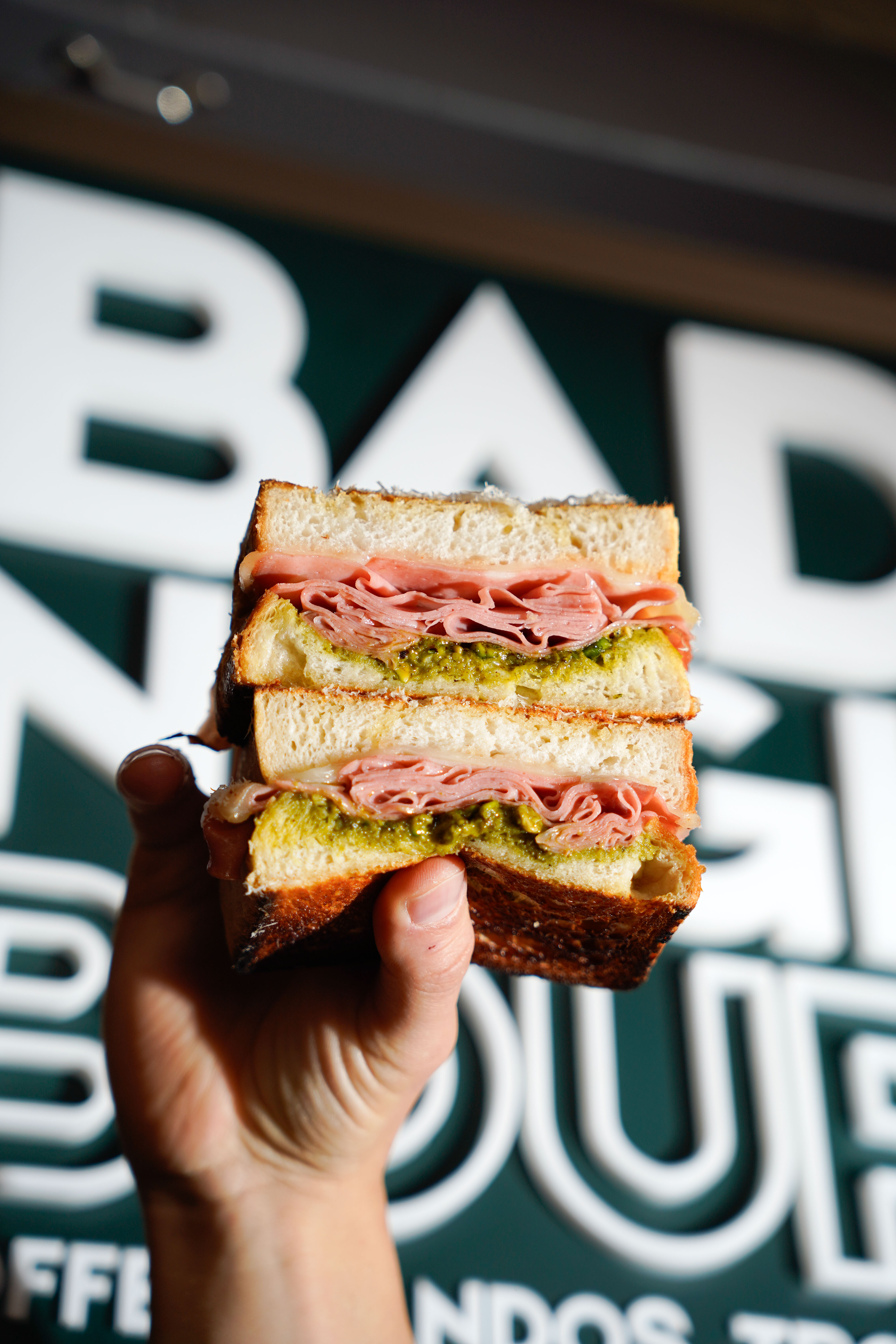 Sando held up in front of the sign